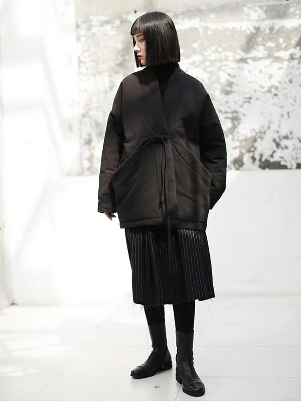 Cotton-linen padded jacket with cinched belt showing tailored waist silhouette