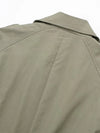 Woman in belted trench coat walking city streets on crisp fall morning