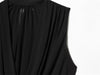 Women's black top with elegant pleats and delicate ribbon accent