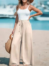 White wide leg beach pants with high waist and drawstring closure on woman