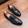 Close-up of the tassel detail on black faux leather loafers for a sophisticated look.