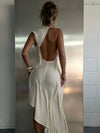 Woman wearing halter neck maxi dress with ruched detailing and asymmetrical hem