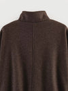 Fall jacket with turtleneck collar and belt cinched for tailored silhouette