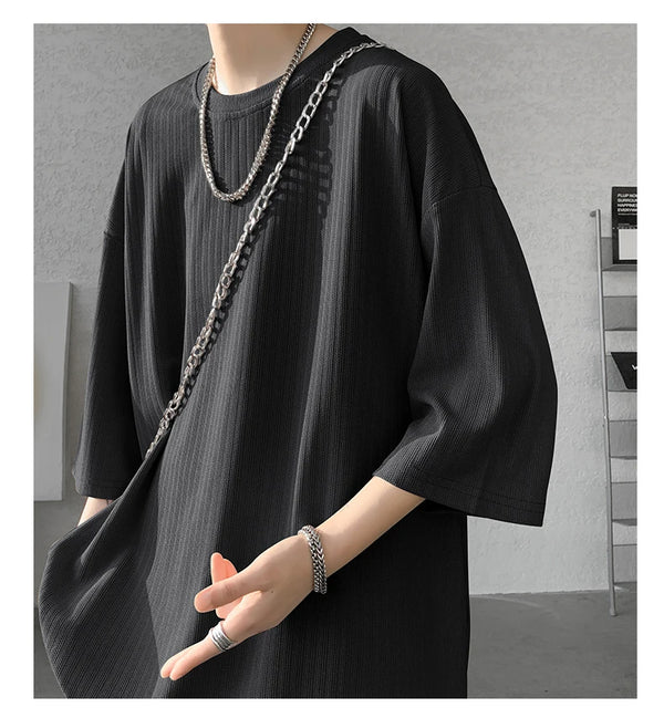 Lifestyle shot of striped summer tee worn at the beach, perfect for sunny days.