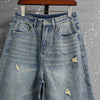 Washed blue denim jeans with generous wide leg cut and soft stretch fabric