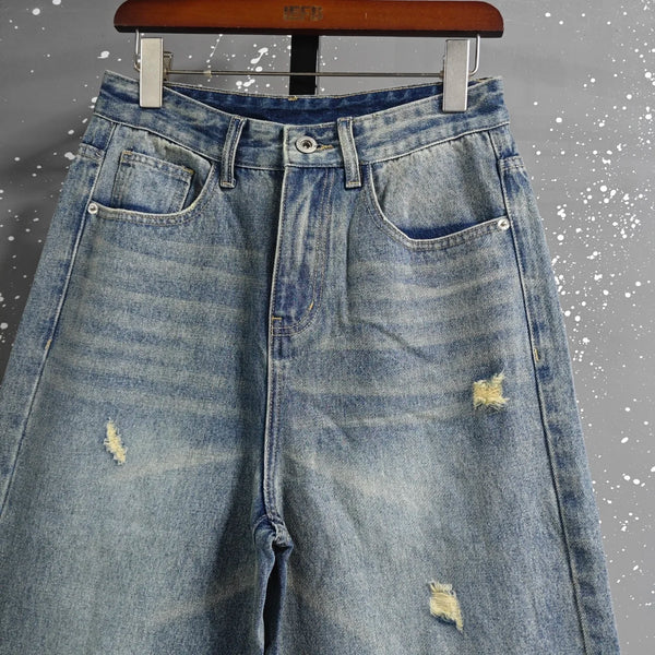 Washed blue denim jeans with generous wide leg cut and soft stretch fabric
