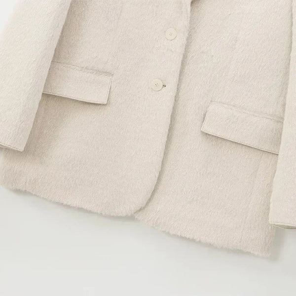 Front button detail and pocket placement on creamy white mohair blazer
