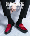 Pair of men's black leather loafers styled with tailored dress trousers