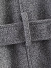 Belted outerwear showing relaxed drape and structured collar detail
