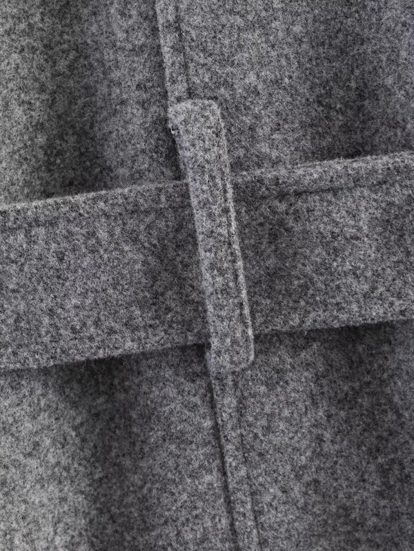 Belted outerwear showing relaxed drape and structured collar detail