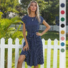 Polka dot pleated midi dress with high waist and flowing skirt on white background