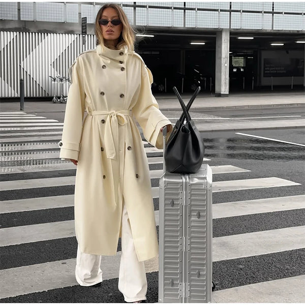 Cream colored long trench coat with traditional button front and belt loops