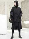 Woman wearing oversized cotton padded winter jacket with adjustable waist belt and hood