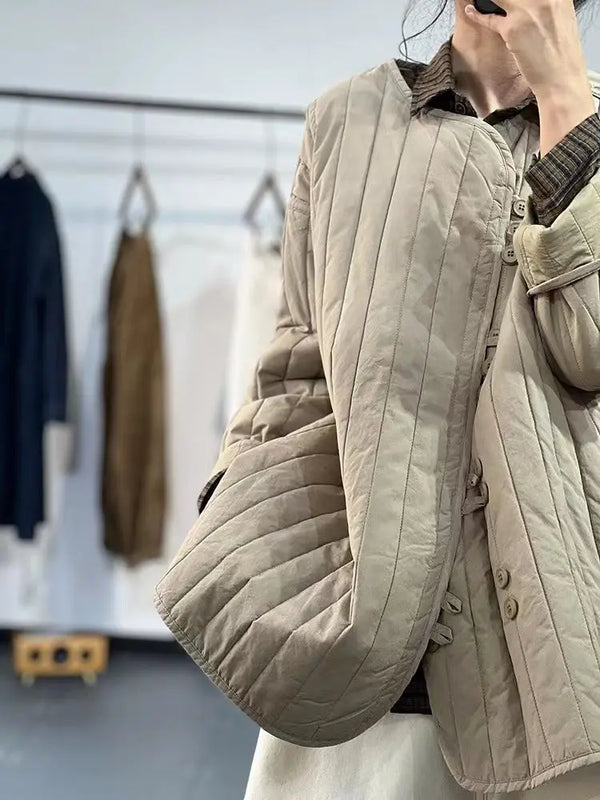 Single-breasted button detail on khaki quilted cotton jacket with decorative closure