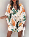 Floral boho V-neck dress with ruffle irregular hem and button front detail on white background