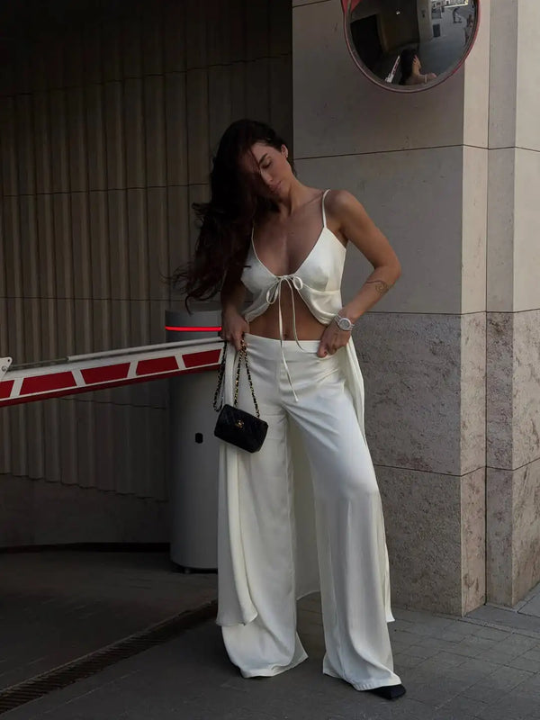 White satin two-piece outfit with luminous finish and tailored collar on white background