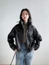 Functional side pockets of the cropped leather jacket for women in black.