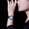 Sophisticated unisex luxury watch with a captivating emerald centerpiece and diamonds.