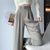 Woman wearing high-waist wide leg trousers with tucked blouse showing elongating silhouette and relaxed fit