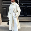 Classic cream colored trench coat with belt tied showing tailored fit