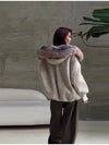Oversized plush jacket styled with jeans and boots for everyday wear