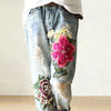 Vintage floral embroidered high-waist denim jeans with loose fit, button fly, and enzyme wash for stylish casual wear.