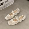 Beige square-toe ballet flats with delicate bow detail and embroidered accents on white background