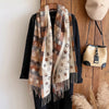 Generously sized printed scarf draped elegantly over a model's shoulders.