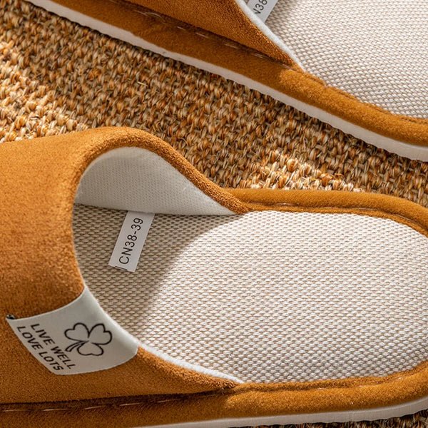 Person wearing beige linen slippers on hardwood floor in cozy home setting