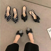 Minimalist pointed sandals with feminine bow detail and secure elastic band fit