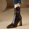Fashion-forward black booties with architectural square toe and zip closure