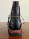 Lace-up closure detail on handcrafted cowhide leather boots.