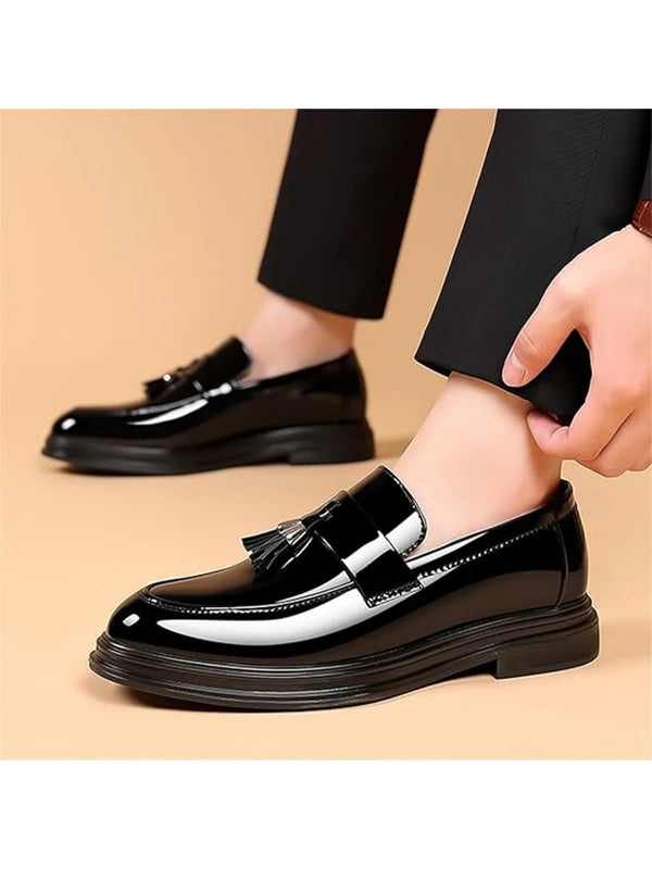 Sleek slip-on penny loafers in polished black leather with elegant tassel detail and classic silhouette