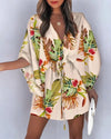 Detail of asymmetrical ruffle hem and flowing fabric on floral V-neck dress