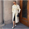 Classic cream trench coat side view showing extended length and movement