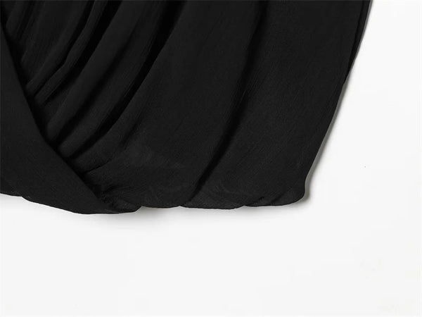 Timeless sleeveless black pleated top with feminine ribbon detail