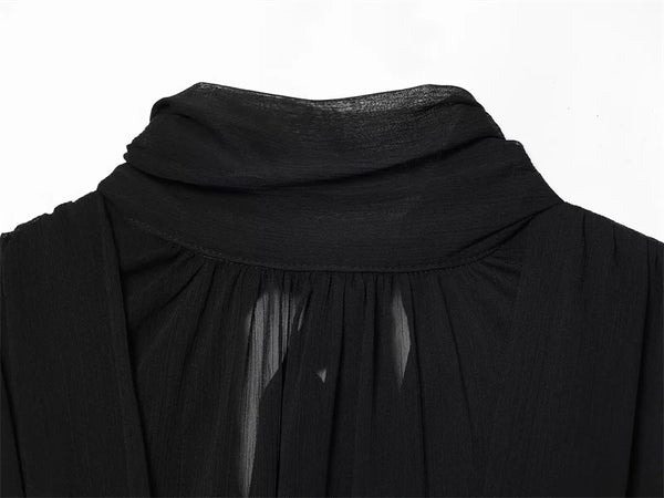 Black pleated top with ribbon detail styled for professional wear