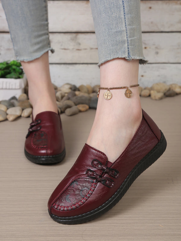 Premium leather loafers with decorative floral accent and slip-on design