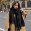 Luxurious black cashmere-polyester blend scarf with fashionable tassels.