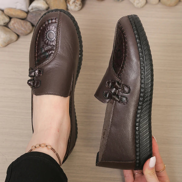 Elegant brown leather loafers with subtle floral accent for effortless style