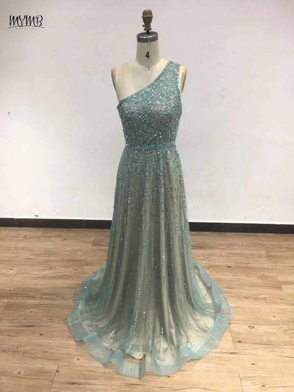 Glamorous look of the beaded gown under chandelier light, emphasizing its captivating design.