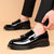 High gloss black tassel penny loafers with mirror-like finish and round toe design for professional wear