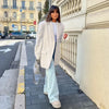 Woman in creamy white mohair blazer at café demonstrating versatile styling for autumn mornings