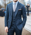 Three-piece blue-grey wool flannel suit with tailored fit and notch lapel.