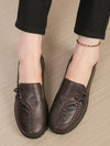 Women's brown leather loafers featuring floral embellishment and slip-on convenience