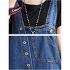 Side angle of streetwear denim jumpsuit showing relaxed fit and adjustable suspender straps