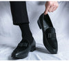Premium black leather dress loafers on executive wearing formal attire