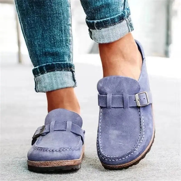 Retro-inspired slip-on mules featuring eye-catching buckle detail and comfortable flat sole