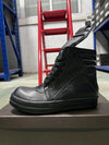 Stylish black leather high-top sneakers on a city street