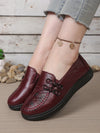 Side view of brown leather slip-on loafers with feminine flower detail